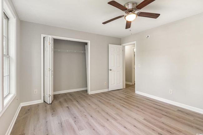 Unfurnished bedroom featuring ceiling fan, baseboards, light wood finished floors, and a closet | Image 13