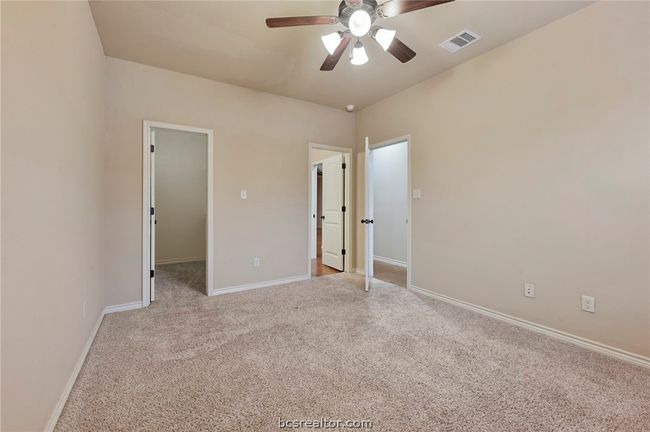 Unfurnished bedroom featuring baseboards, visible vents, a spacious closet, light colored carpet, and a ceiling fan | Image 10
