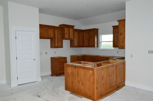 Kitchen with vaulted ceiling and brown cabinets | Image 10