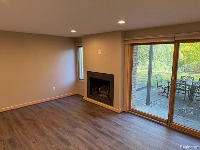 Unfurnished living room with recessed lighting, dark wood-type flooring, and a fireplace | Image 6