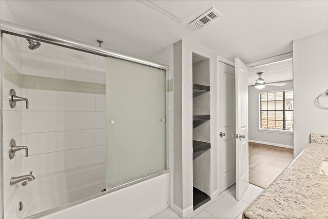 Bathroom with shower / bath combination with glass door, vanity, ceiling fan, and a textured ceiling | Image 27