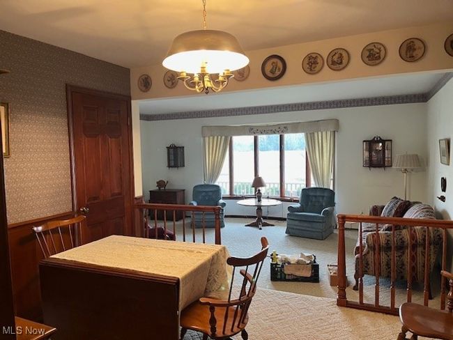 Carpeted dining room with a chandelier | Image 18