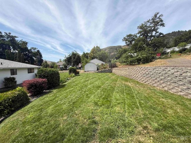View of grassy yard featuring a storage shed | Image 9