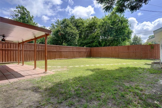 Large fenced backyard featuring a patio | Image 19