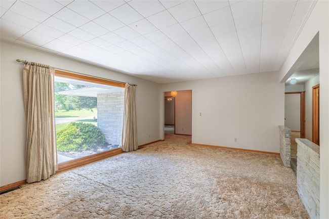 Spare room with wooden walls, ceiling fan, wood finished floors, and baseboards | Image 10