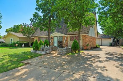 View of front facade featuring an outbuilding, a garage, and a front lawn | Image 1