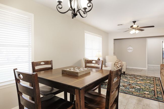 Dining room featuring ceiling fan with notable chandelier and baseboards | Image 10