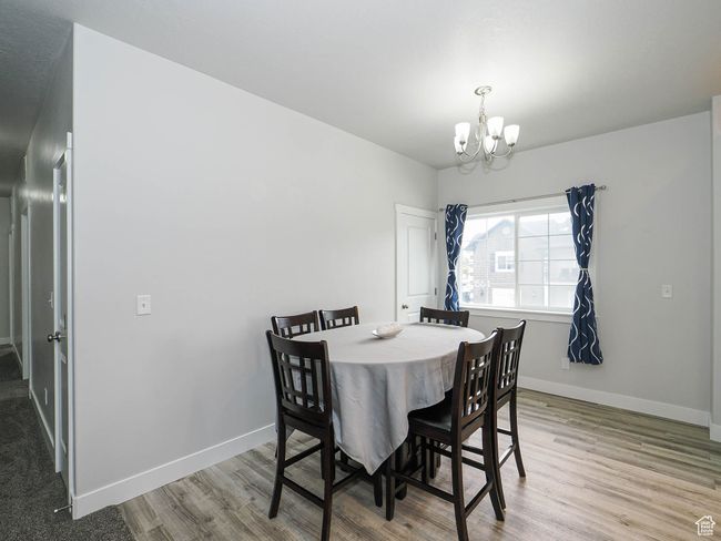 Dining room with baseboards, a chandelier, and wood finished floors | Image 17