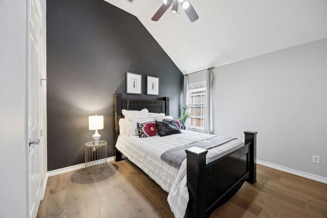 A sleek design and modern ceiling fan complement the high ceilings and large window, creating an inviting and comfortable space for guests or household members. | Image 25
