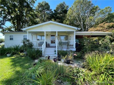 Bungalow-style home with a front lawn and covered porch | Image 1