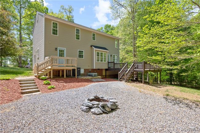 Back of property with central AC unit, a fire pit, stairs, and a deck | Image 35