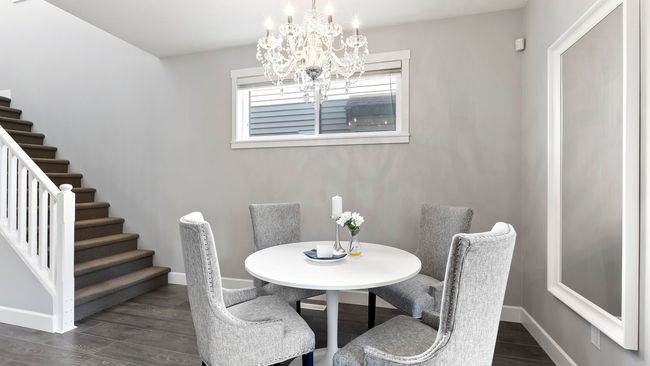 Dining area featuring a chandelier, dark wood-type flooring, baseboards, and stairs | Image 9