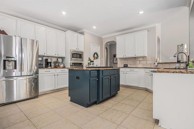 Kitchen with island with a gas cooktop | Image 15