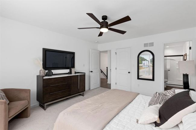 Bedroom featuring ceiling fan, connected bathroom, and light carpet | Image 25