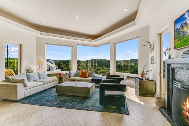 Living room with a tray ceiling, plenty of natural light, a premium fireplace, recessed lighting, and ornamental molding | Image 7