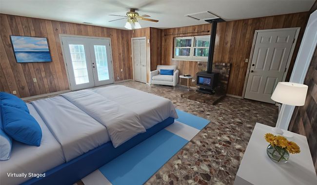 Virtual Staging. Bedroom featuring a wood stove, wood walls, french doors, ceiling fan, and access to outside | Image 8