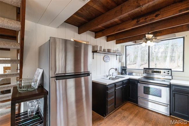 Kitchen with beam ceiling, a sink, wood finished floors, appliances with stainless steel finishes, and light countertops | Image 14