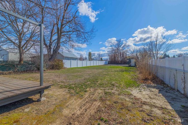 Fenced backyard with a wooden deck | Image 25