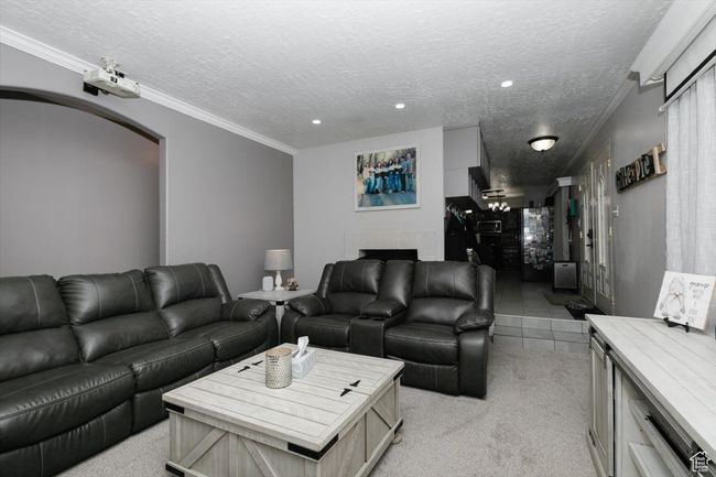 Living area with a textured ceiling, recessed lighting, light carpet, and arched walkways | Image 6