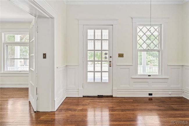 Entryway featuring wood flooring, wainscoting, a decorative wall, and crown molding | Image 5