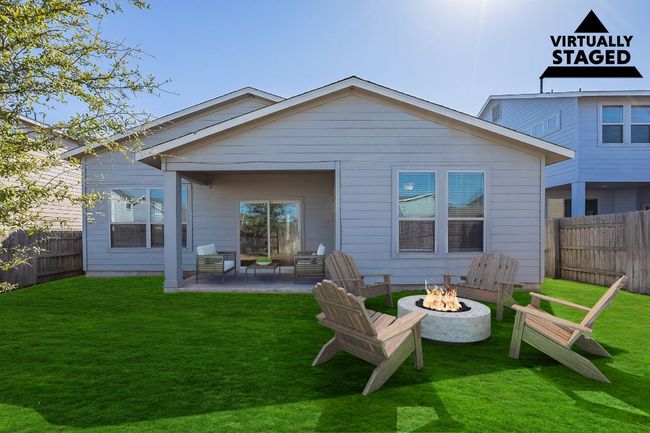 Rear view of property with a fenced backyard, a fire pit, a patio area, and a yard | Image 32