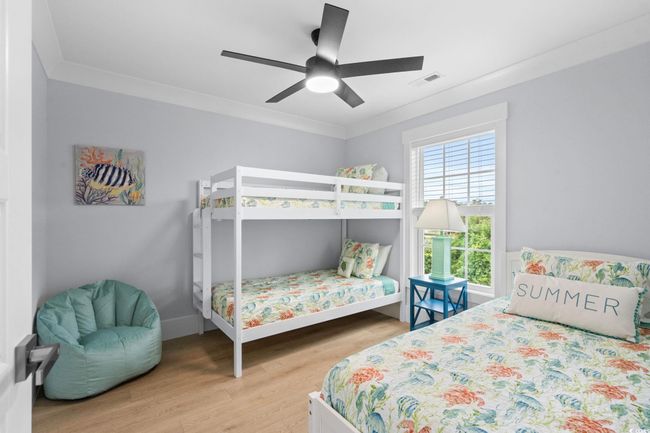 Bedroom with light wood-style flooring, crown molding, and ceiling fan | Image 16