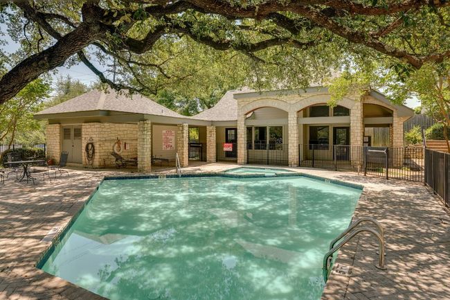 View of swimming pool featuring a patio area and a pool with connected hot tub | Image 29