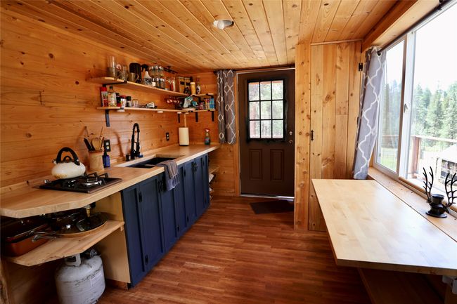 Indoor wet bar featuring wood ceiling, dark wood-type flooring, wooden walls, and gas stovetop | Image 41