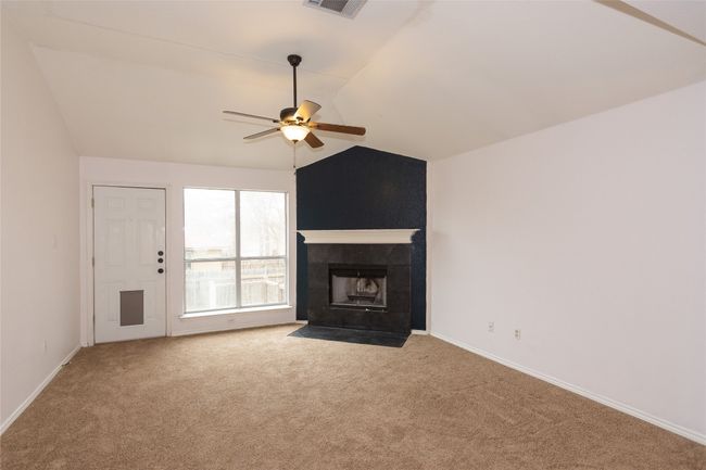 Living room featuring lofted ceiling and a tile fireplace. | Image 11