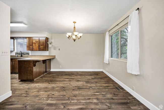 Kitchen with plenty of natural light, a chandelier, a breakfast bar area, and a peninsula | Image 9