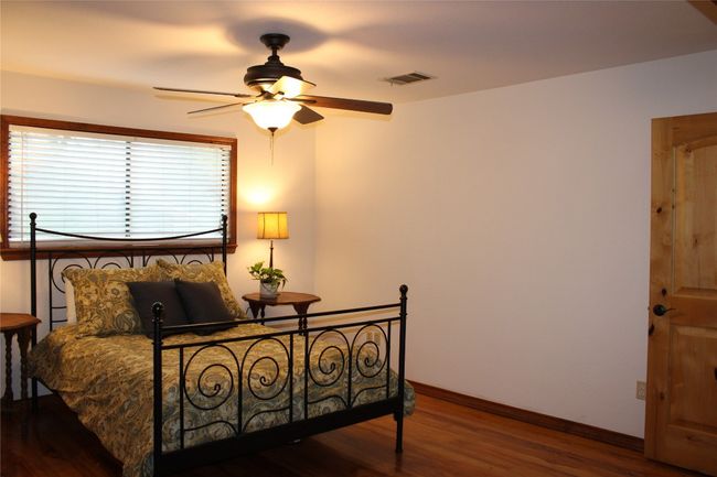 Bedroom with wood finished floors, baseboards, and ceiling fan | Image 14