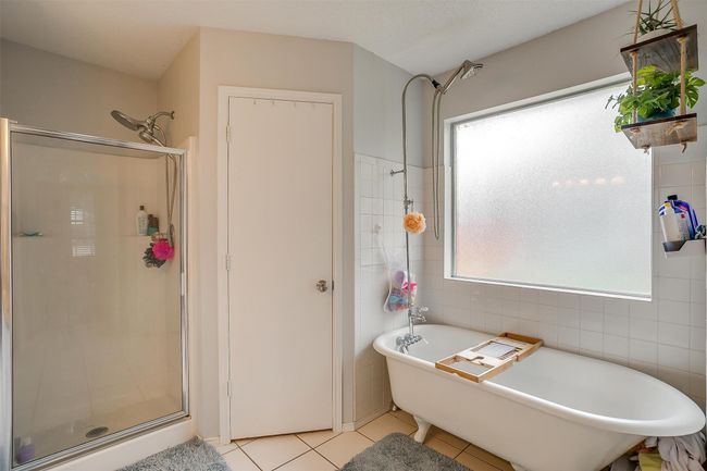 Full bath with tile patterned floors, a freestanding tub, a shower stall, and tile walls | Image 28