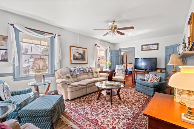 Living area featuring a ceiling fan and wood finished floors | Image 4