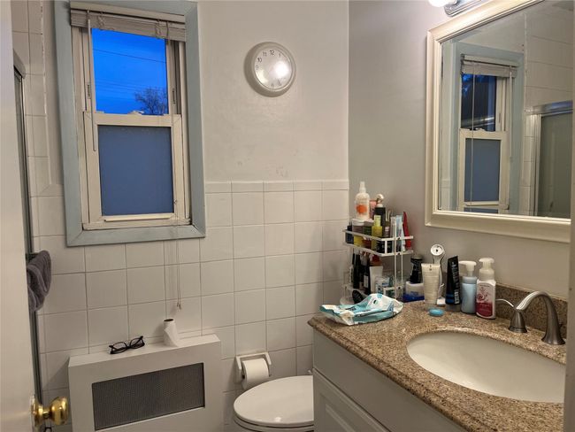 Bathroom with vanity, tile walls, and toilet | Image 11