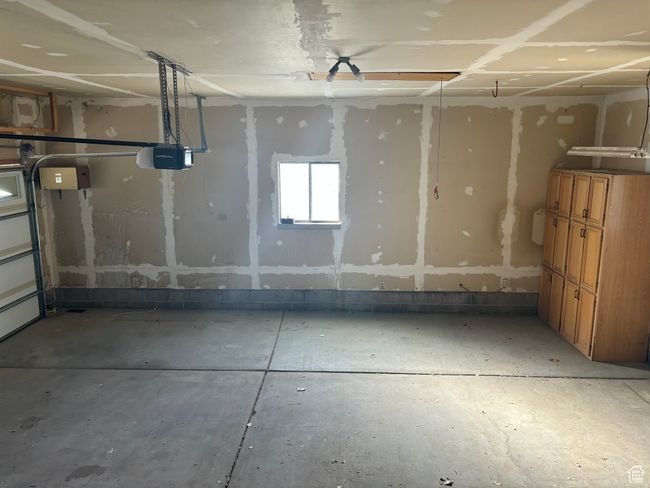 Spacious garage featuring a garage door opener | Image 26
