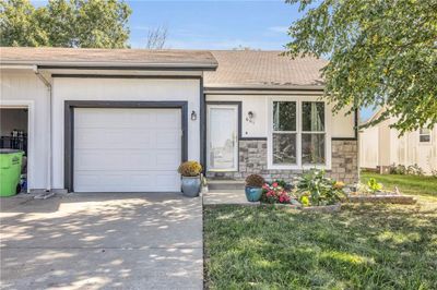 Ranch-style home featuring a front lawn and a garage | Image 2