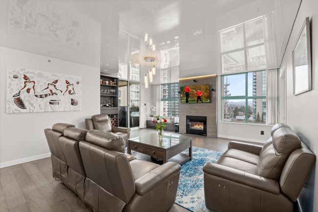 Living area featuring baseboards, wood finished floors, and a glass covered fireplace | Image 8