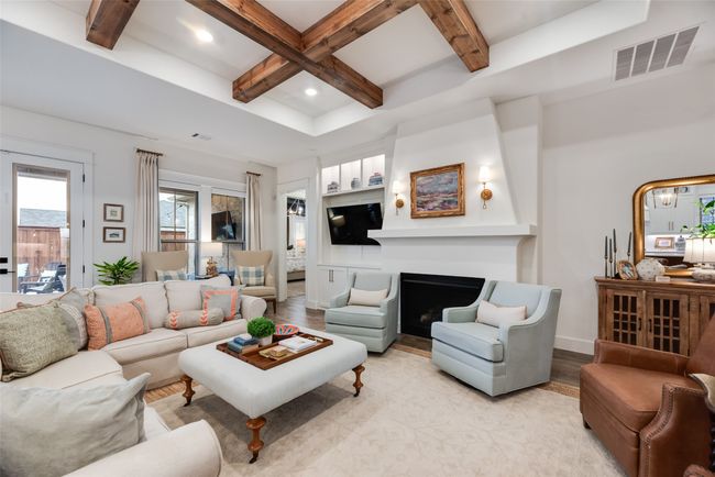 Living room with light wood-type flooring, coffered ceiling, beam ceiling, recessed lighting, and a fireplace | Image 7
