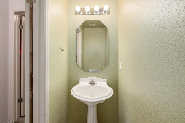 Powder bath is conveniently tucked downstairs next to the laundry room. | Image 25
