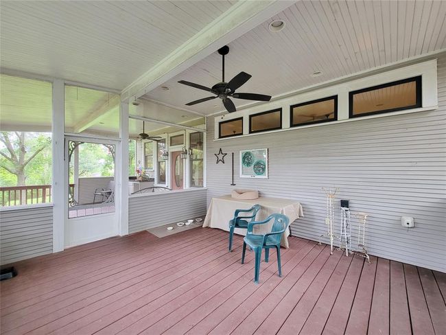 Enjoy serene outdoor living on the breezy screened porch, seamlessly connecting to a charming brick patio and greenhouse. | Image 30