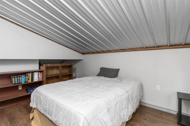 Apartment bedroom with vaulted ceiling and wood finished floors | Image 36