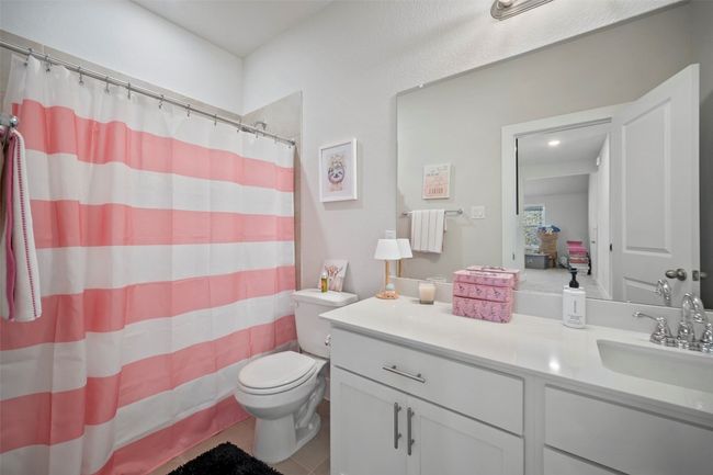 Bathroom with vanity, tile patterned flooring, and curtained shower | Image 32