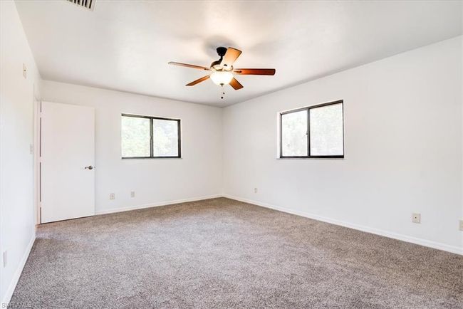 Unfurnished room with a wealth of natural light, a ceiling fan, carpet flooring, and baseboards | Image 13