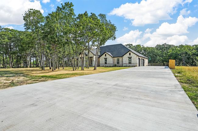French country home with stone siding and concrete driveway | Image 10
