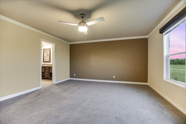 Unfurnished room featuring ceiling fan, ornamental molding, light colored carpet, and plenty of natural light | Image 12