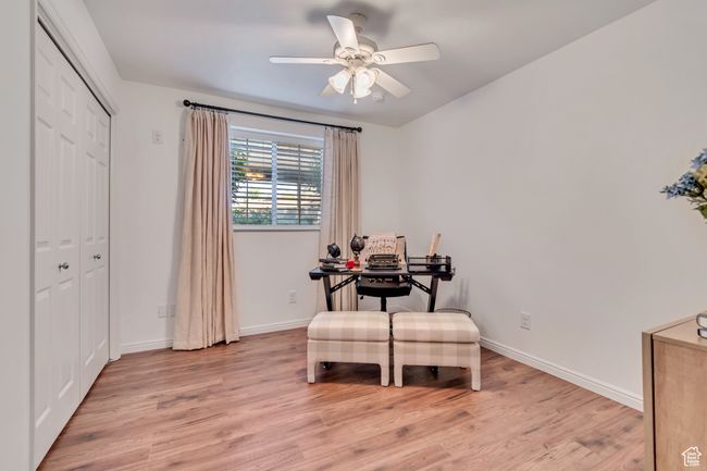 Office space with light wood-style floors, ceiling fan, and baseboards | Image 12