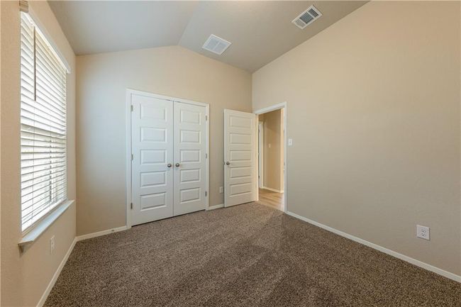 Unfurnished bedroom with lofted ceiling, carpet flooring, multiple windows, a closet, and baseboards | Image 15