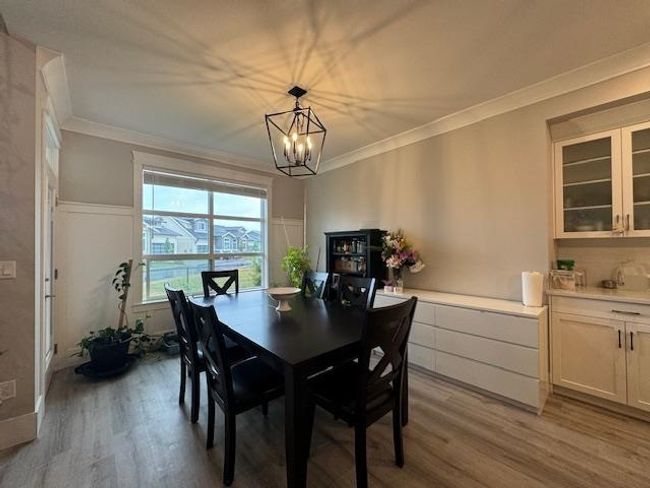 Dining room featuring light wood-type flooring, a chandelier, and ornamental molding | Image 21