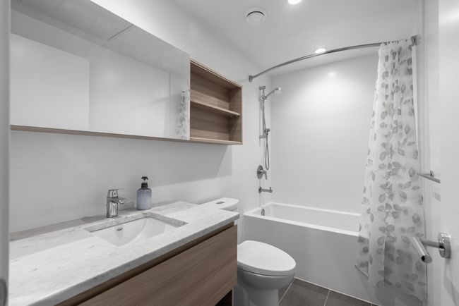 Bathroom with vanity, shower / tub combo with curtain, toilet, tile patterned flooring, and recessed lighting | Image 8