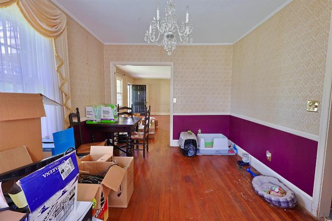 Dining room featuring wallpapered walls, crown molding, wood-type flooring, and a chandelier | Image 20